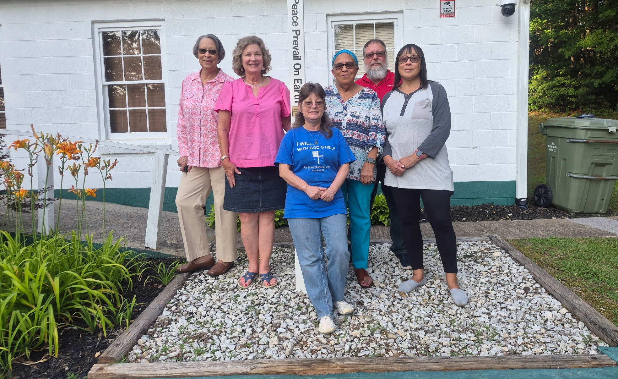 All Saints outreach team gathered by the peace pole outside the parish building